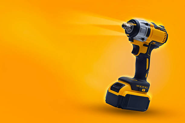 istock Cordless impact wrench on yellow background with dynamic light. Electric tool for construction, car repair and DIY projects. 2212469967