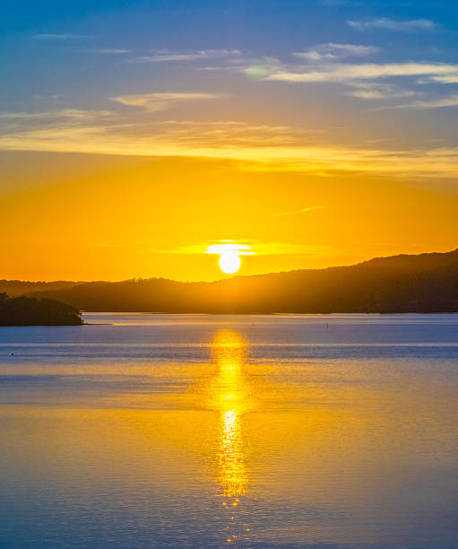 istock Sunrise with high cloud, boats and reflections over the water 2212471811