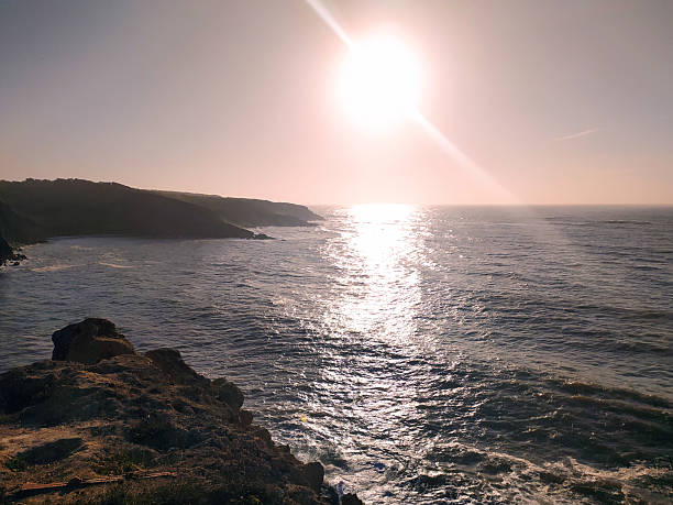 istock Serene coastal view featuring a dazzling sun over the ocean, reflecting light on the water. Ideal for travel, nature, or inspirational content, conveying peace. 2212475144