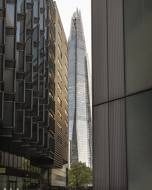 Perspective of Alley with The Shard skyscraper and some of the modern glass buildings exterior in more london riverside. London, UK - Apr 27, 2025 - Perspective of Alley with The Shard skyscraper and some of the modern glass buildings exterior in more london riverside. use it as your Wallpaper, Poster and Space for text, Selective focus. the shard close up stock pictures, royalty-free photos & images