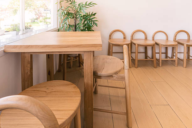 istock Bright modern interior with natural wooden table and curved back stools near window and indoor plant 2212484493