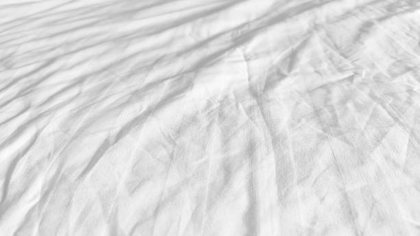 istock White and wrinkled bed sheet wave background. close up wave fabric. 2212485760
