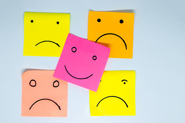istock concept for a positive attitude with small office notes with multiple faces and one that stands out with a smile 2212486951