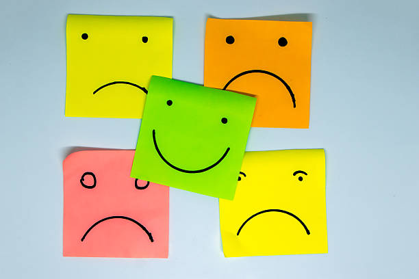 istock concept for a positive attitude with small office notes with multiple faces and one that stands out with a smile 2212487040