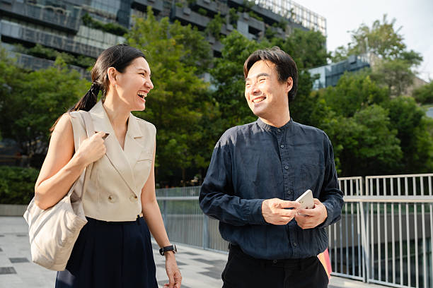 istock Two colleagues walking to work together with their morning coffee 2212496781