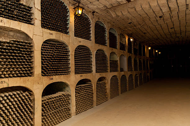 istock Ancient underground wine cellar with dusty bottles on shelves 2212508425