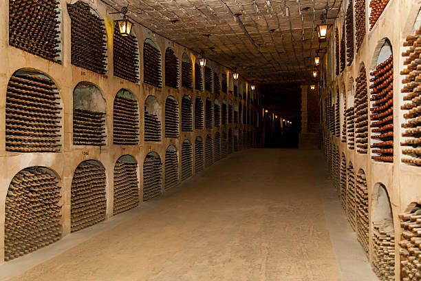 istock Ancient underground wine cellar with rows of aging bottles 2212508440