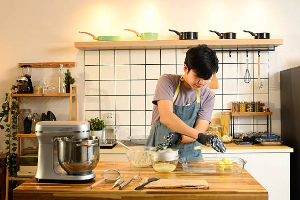 istock Young man squeezing and separating freshly made butter by hand on a kitchen counter 2212510887