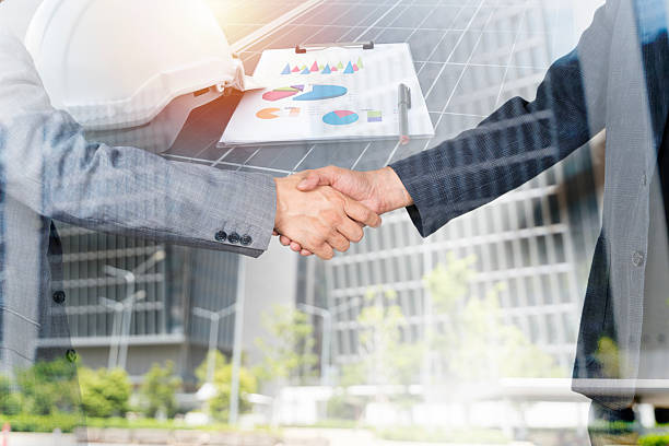 istock Business professionals shaking hands over solar panels reflecting a commitment to renewable energy 2212512121