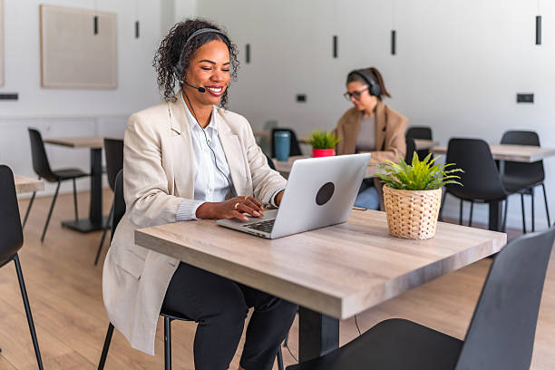 istock Smiling black customer service representative working on laptop in coworking space 2212513579