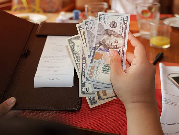 istock woman hand with a Bill With American Dollars which people, payment and finances concept 2212517543