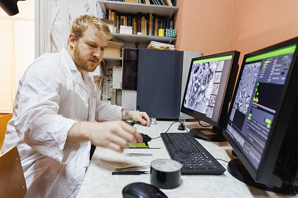 istock University assistant using computer and checking the results of students' practice research 2212518389