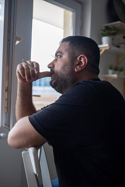 istock Worried man smoking a cigarette 2212520250