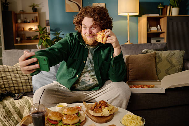 istock Eating Pizza While Taking Selfie in Cozy Living Room 2212521193