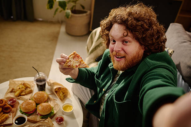 istock Young Man Enjoying a Fast Food Feast at Home 2212521243