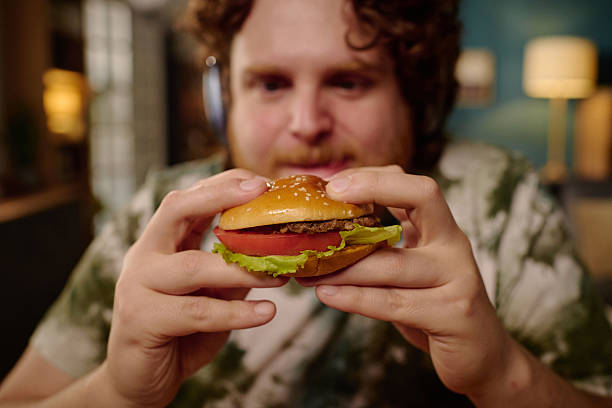 istock Man Holding Delicious Hamburger with Both Hands 2212521412