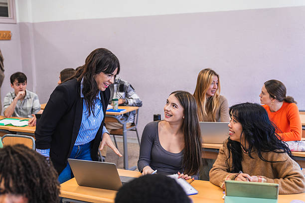 istock High school teacher interacting with students in classroom 2212522992