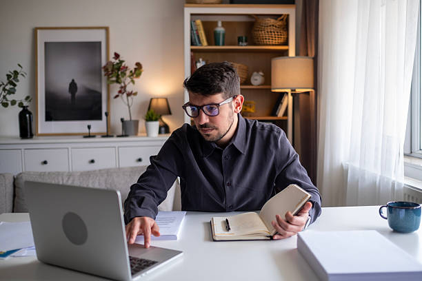 istock Focused man working on laptop in modern office environment. 2212523446