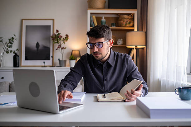 istock Focused man working on laptop in modern office environment. 2212523451