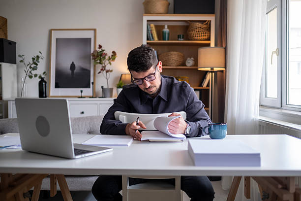 istock Focused man working on laptop in modern office environment. 2212523492