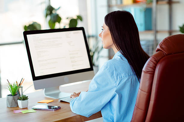 istock Confident young professional woman working at her desk in a modern office environment, focusing on her computer screen 2212524604