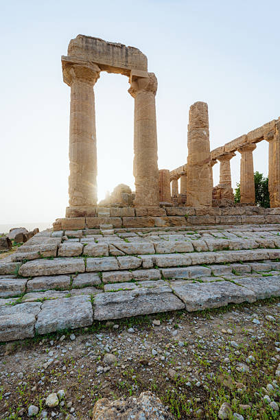 Ancient Temple of Juno at the renowned Valley of the Temples in Agrigento, Sicily, showcasing awe-inspiring Greek architecture amidst a rugged landscape bathed in warm sunlight.