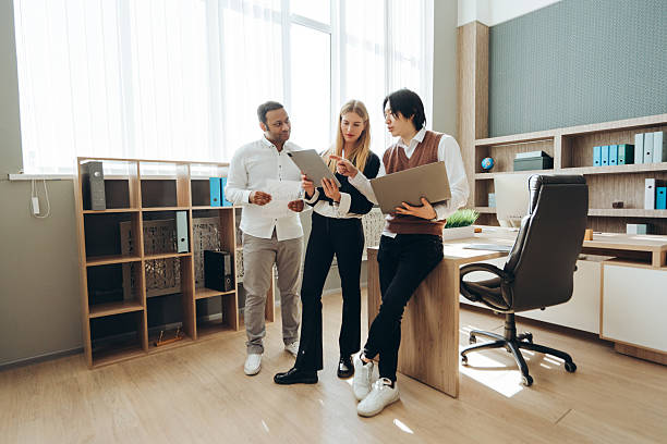 istock Business team analyzing data on tablet and laptop in modern office 2212526269