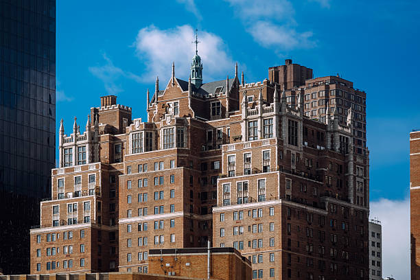 Stunning old-style architecture with intricate details on a sunny day. Captured in Manhattan, New York City, showcasing urban elegance and historic charm under a vibrant blue sky.