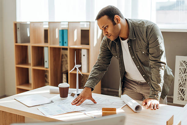 istock Engineer analyzing blueprints for a wind turbine project in the office 2212527226