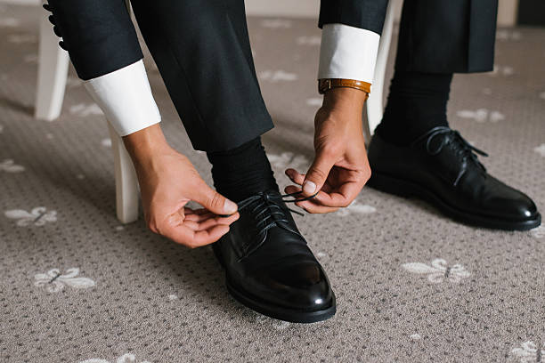 istock Elegant Groom Adjusting Shoes For Wedding 2212528609