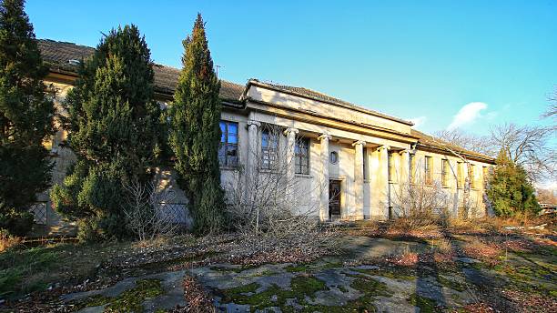 istock Abandoned neoclassical building in Schonebeck, Germany, with tall columns, broken windows, and overgrown vegetation 2212529718