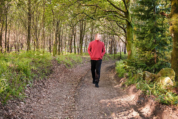 istock man walking on a path in the woods enjoying nature 2212530140