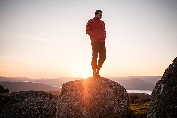 istock Hiker standing on rock enjoying scenic sunrise over mountains 2212530282