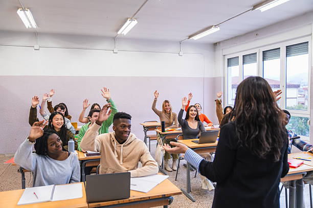istock High school students raising hands in classroom during lesson 2212530813