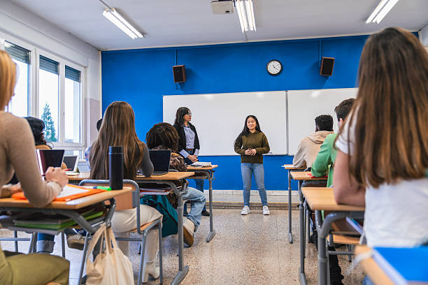 istock High school student giving presentation to classmates and teacher 2212531653