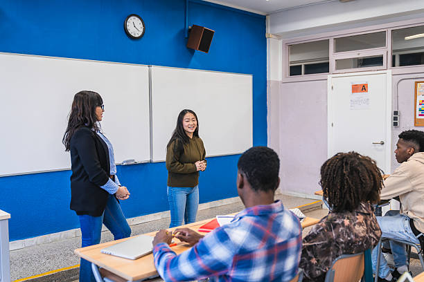 istock High school student giving presentation to classmates and teacher 2212531811