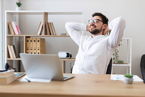 istock Man taking a break at office workstation enjoying relaxation 2212533005
