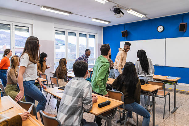 istock High school students moving around in classroom during break time 2212534622