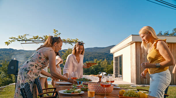 istock Friends Preparing a Table for Lunch in a Beautiful Garden 2212535322