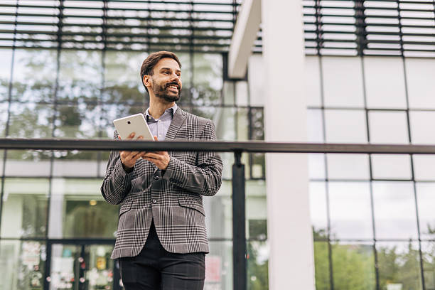 istock Businessman using digital tablet outside modern office building 2212535508
