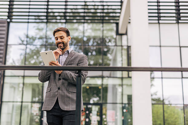 istock Businessman using digital tablet outside modern office building 2212535514