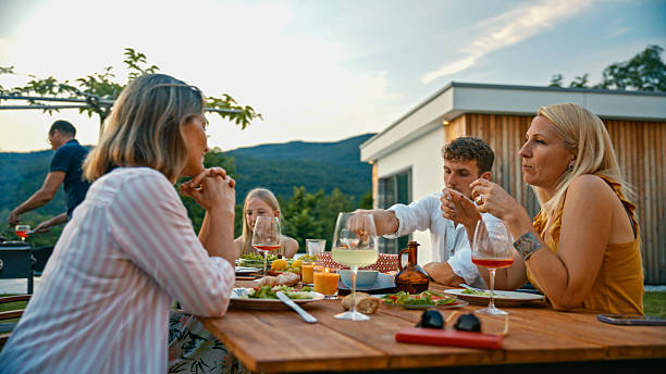 istock Family Enjoying Dinner Together on a Summer Evening 2212535910