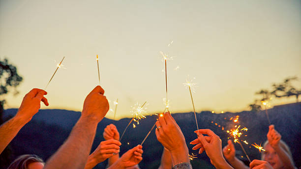 istock Friends Holding Burning Sparklers Celebrating at Sunset 2212535963