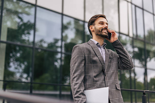 istock Businessman talking on phone outside office building 2212536611