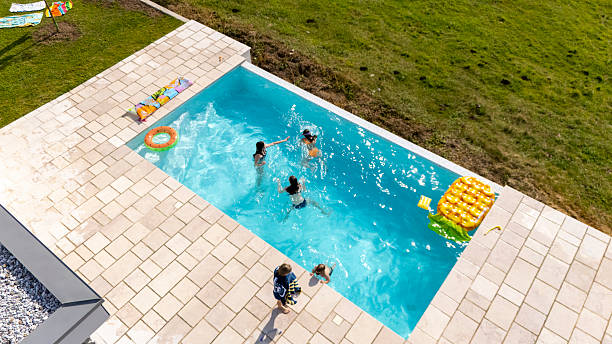 istock Children Playing in a Backyard Swimming Pool During Summer Vacation 2212536714
