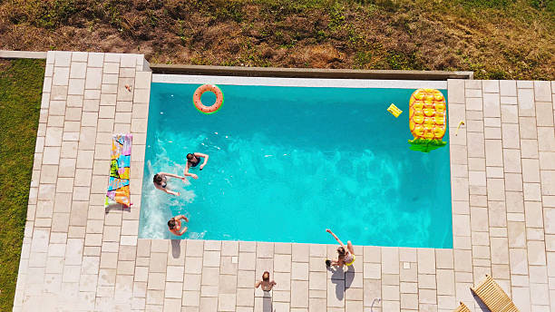 istock Friends Playing in Swimming Pool During Summer Holidays 2212536743