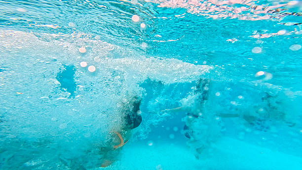istock Children Playing Underwater in a Swimming Pool Creating Bubbles 2212536748