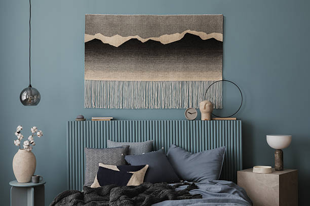 istock A stylish bedroom featuring a textured blue headboard, a modern bedside table, and natural cotton stems. A balance of warm and cool tones creates a relaxing mood. 2212536864