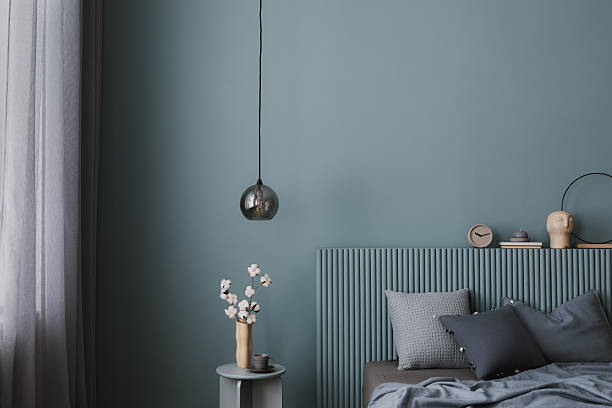 istock A sophisticated bedroom featuring a ribbed headboard, layered pillows, and sculptural decor. Muted blue tones and natural materials create a harmonious retreat. 2212536886