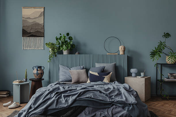 istock A cozy bedroom area adorned with textured throws, neutral-toned cushions, and warm lighting. Home decor. Blue tones. 2212536921
